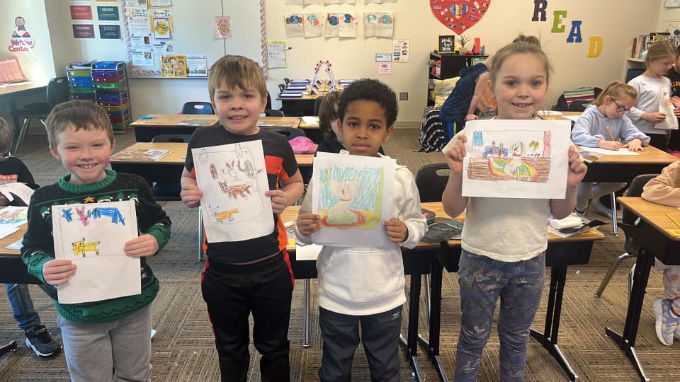 Four children holding artwork