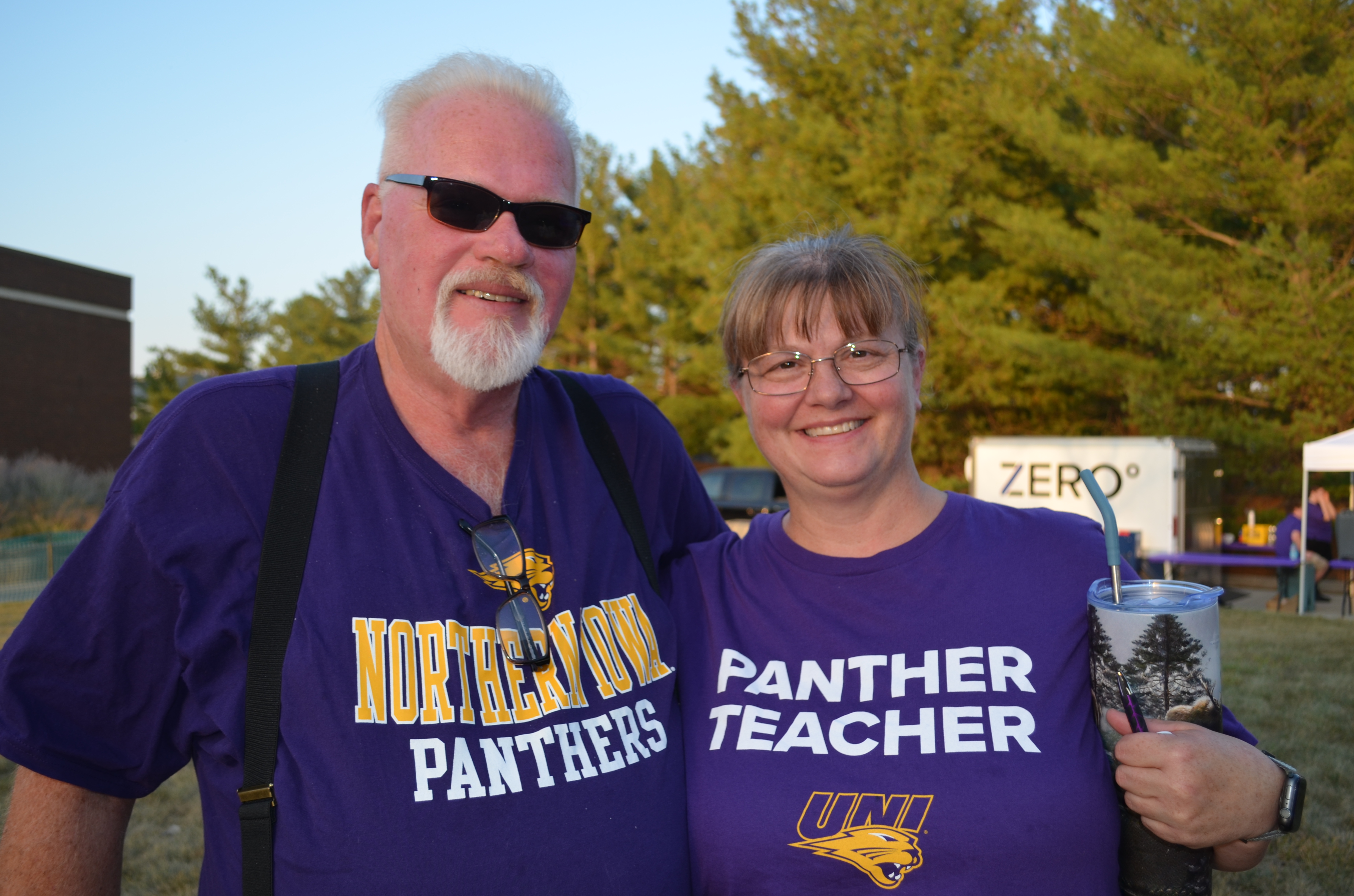 Alumni couple with UNI shirts on campus at Homecoming Bash