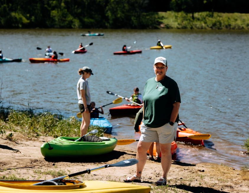 RTNL alumna with kayaking students at lake