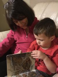 an early childhood home visitor reads with a child