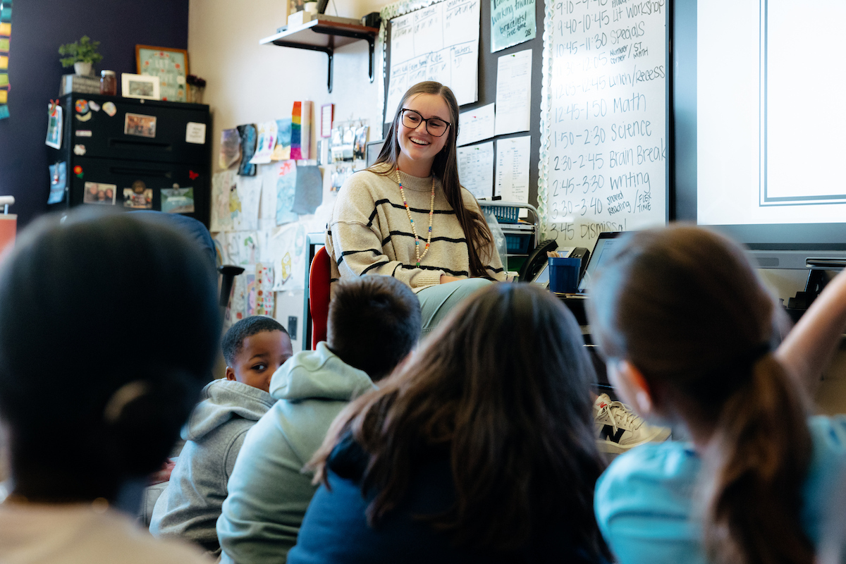 Student teacher in front of classroom of elementary kids