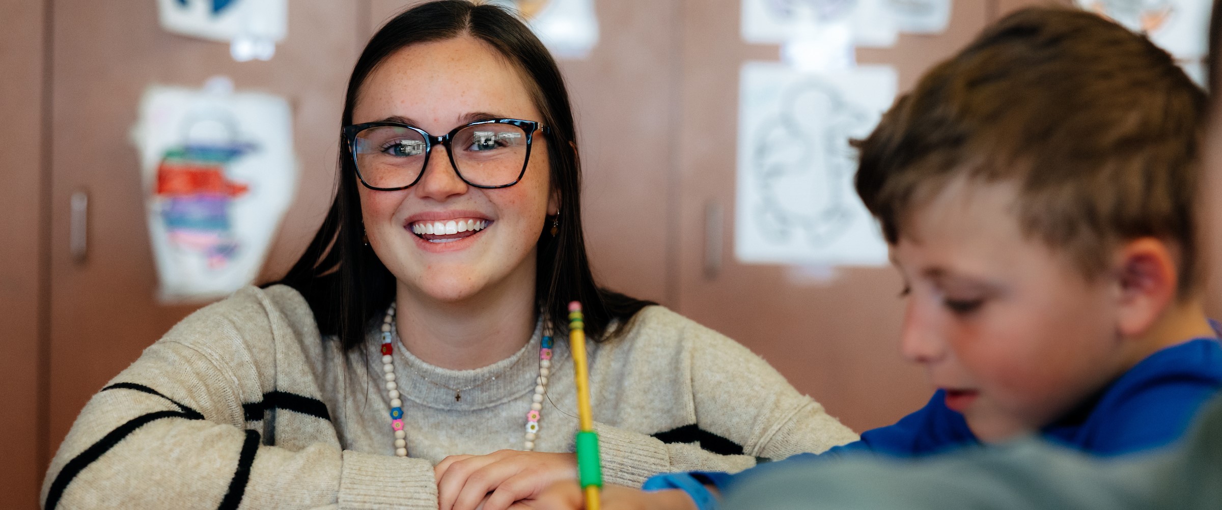 Ashley Van Heukelom working with elementary student 