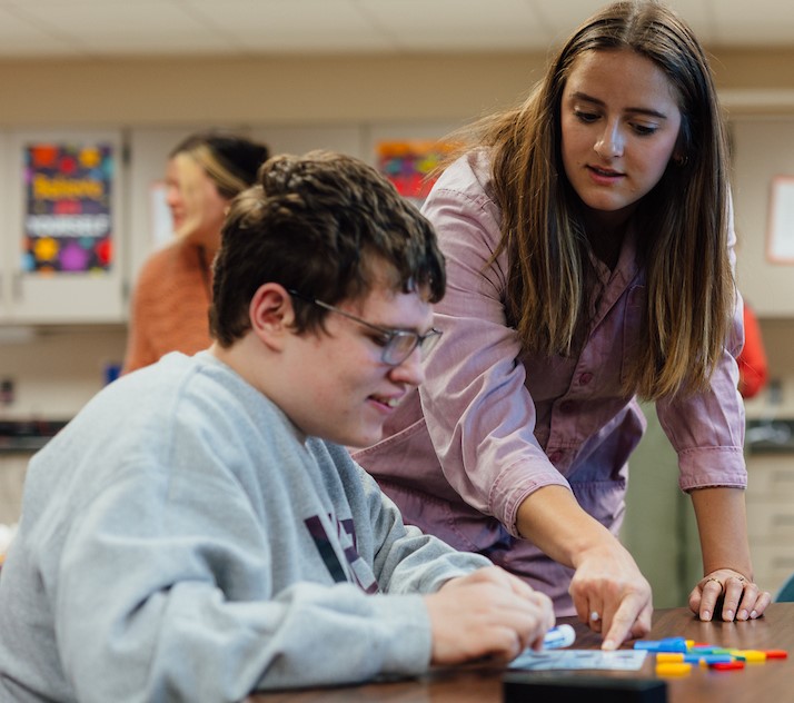 Student teacher in classroom with student 