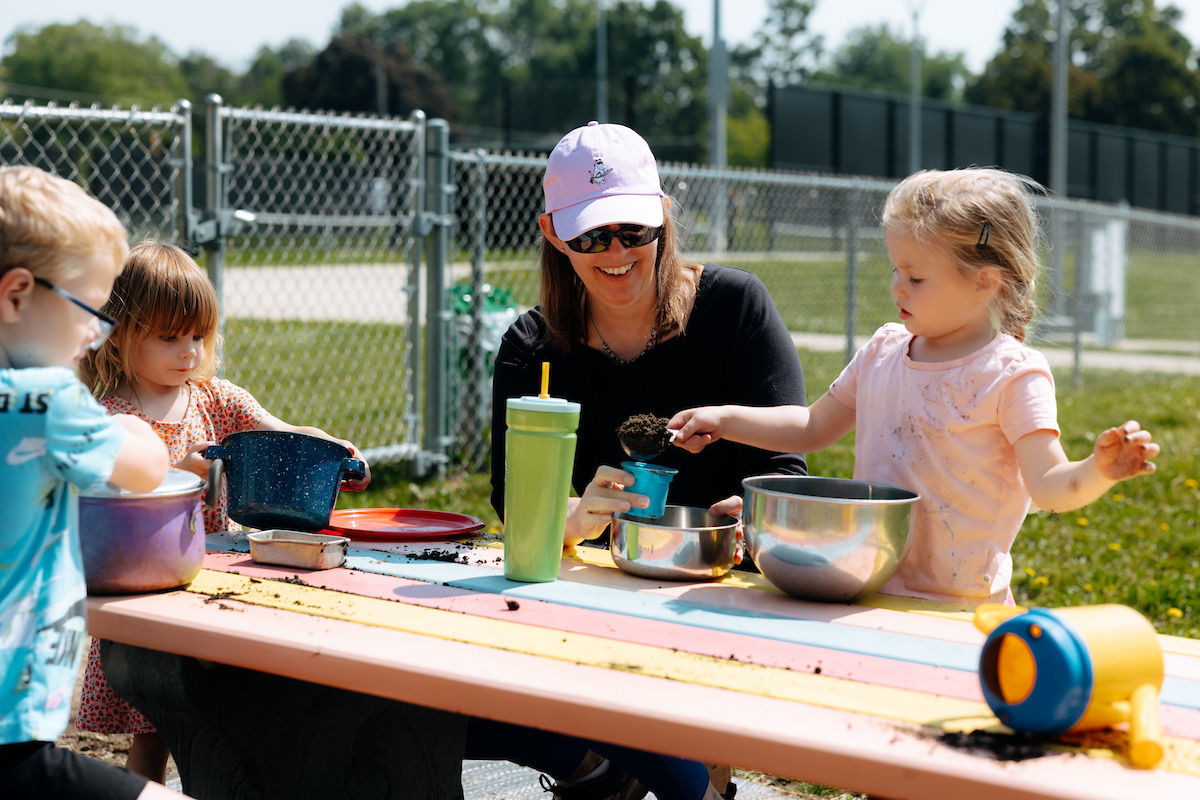 Preschoolers playing at picnic table outside child care center