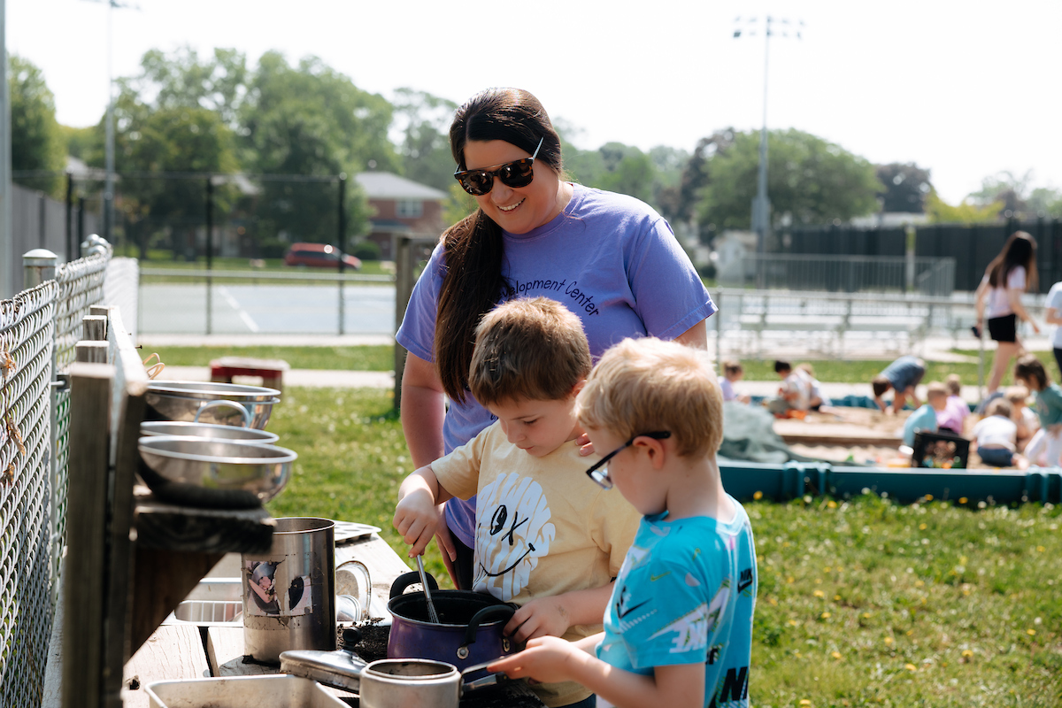 Director Maria Ackerson guiding two boys in play at the Child Development Center