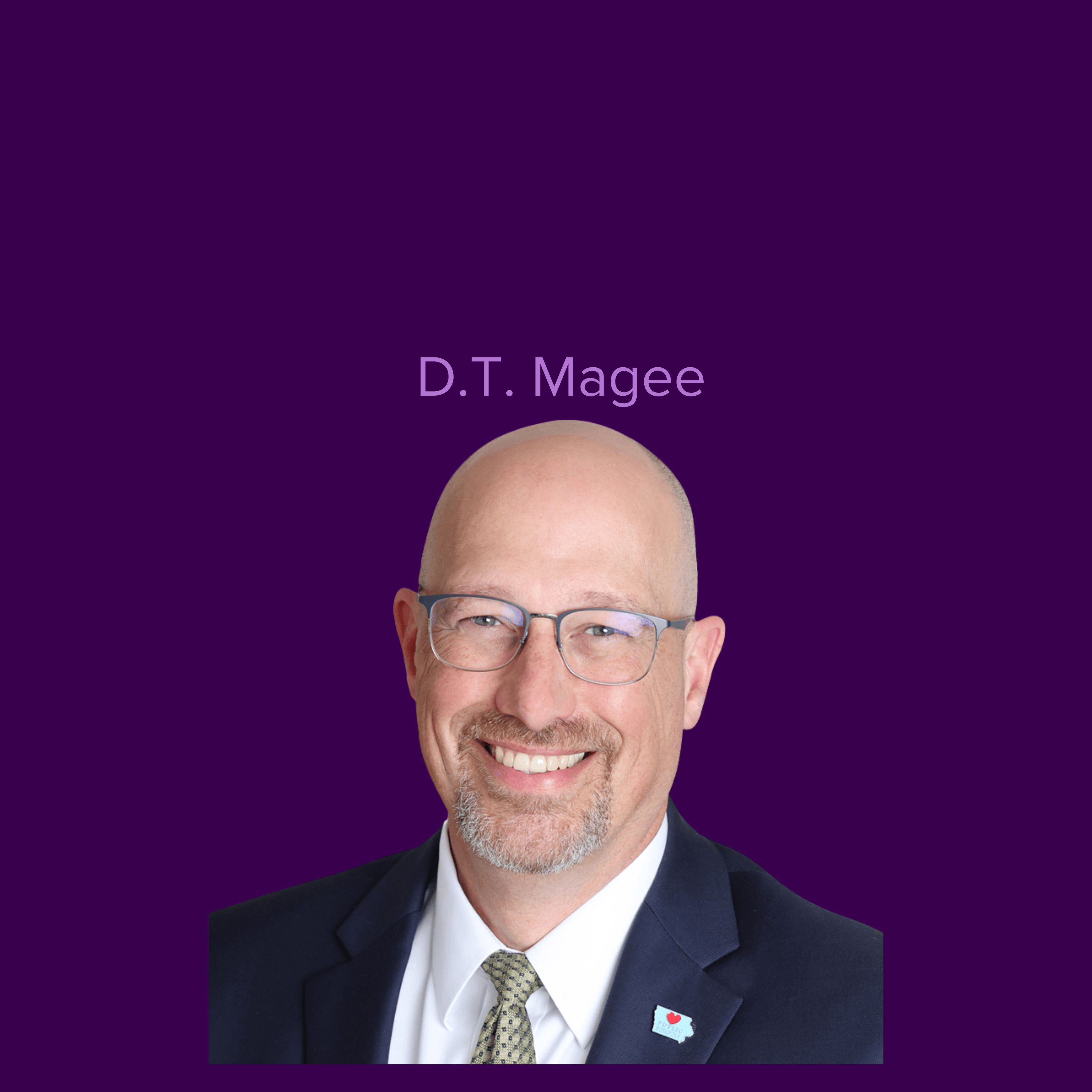 A picture of smiling DT wearing glasses and a suit and tie