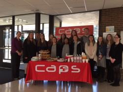 CAPS students pose behind a refreshment table