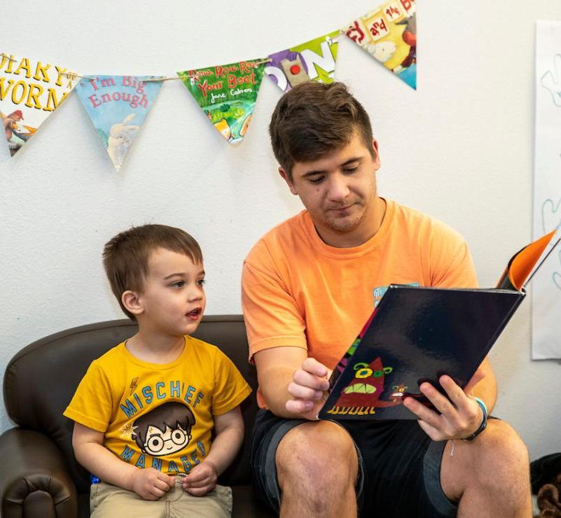 Student reading to a small child.