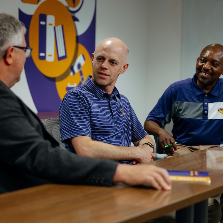 Matt Townsley talking with colleagues in conference room