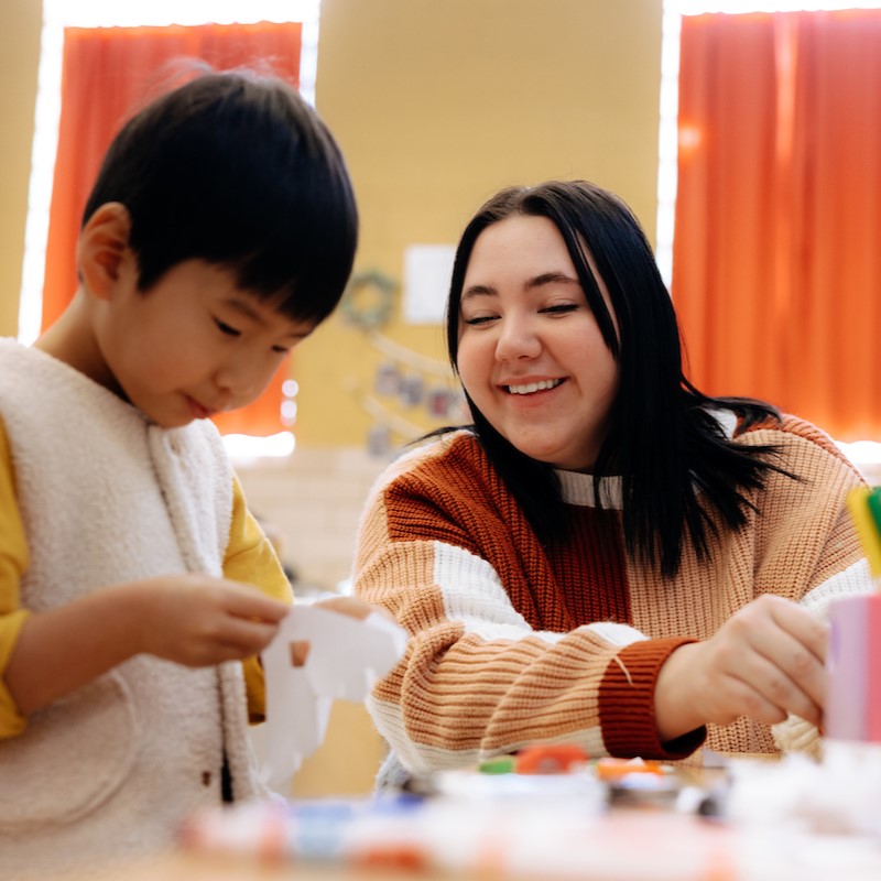 Katelyn Kane at child development center with child at table