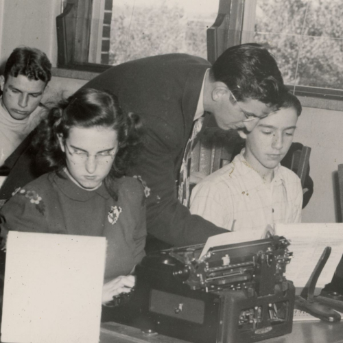 Teacher working with students in business class at Price Lab 